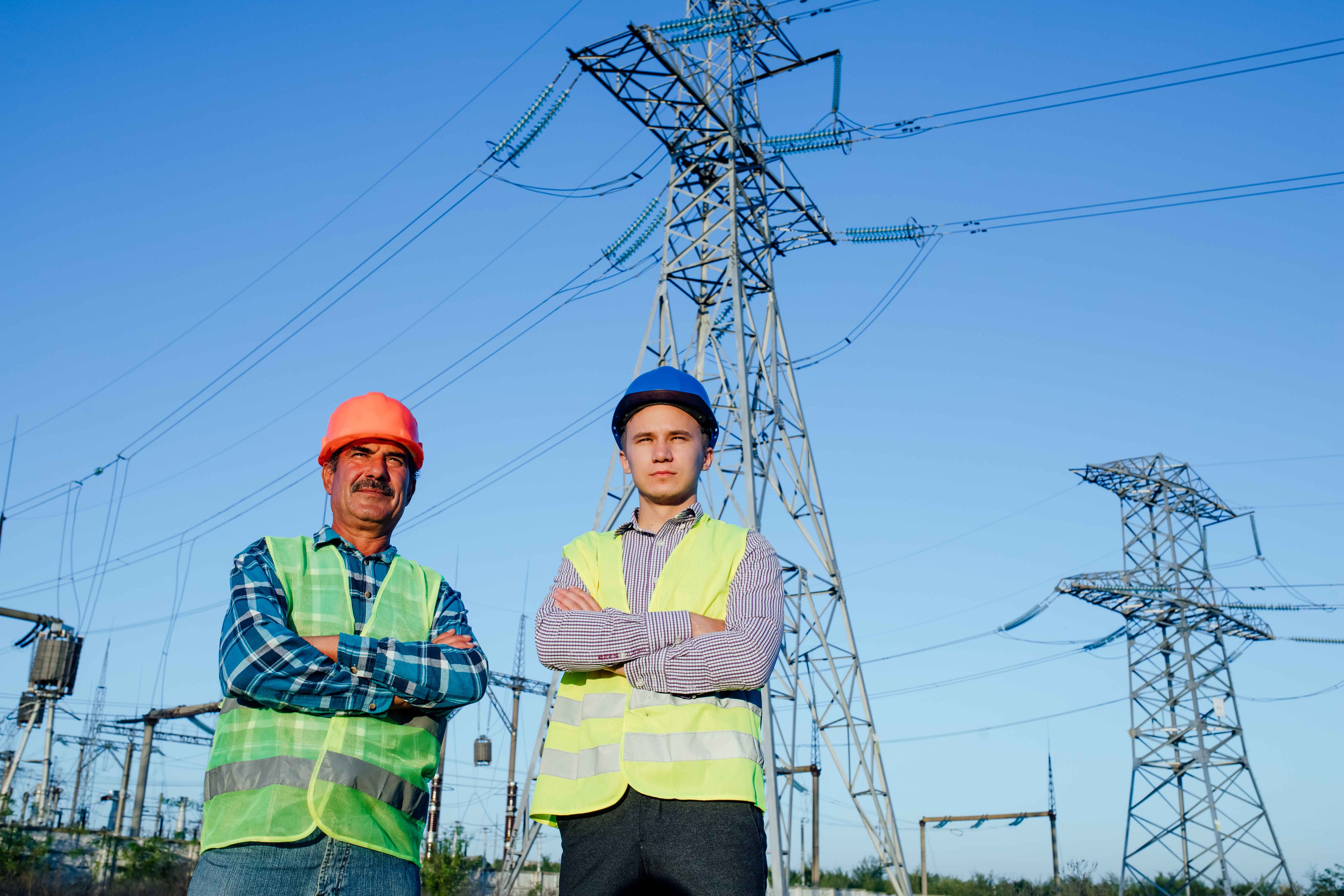 serious-technicians-in-hardhats-standing-near-high